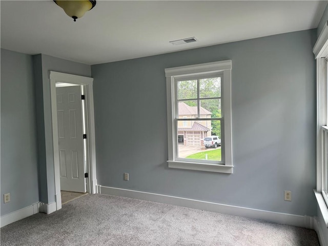 spare room featuring carpet floors and baseboards