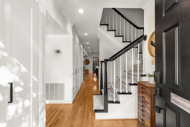 entrance foyer with light wood-type flooring and crown molding