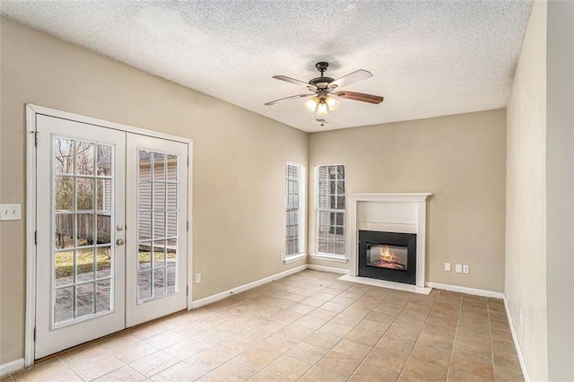 unfurnished living room featuring light tile patterned floors, plenty of natural light, french doors, and ceiling fan