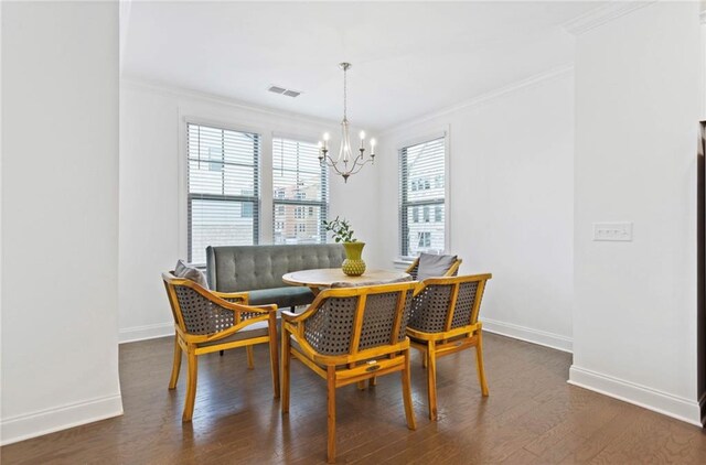 dining space featuring an inviting chandelier, dark hardwood / wood-style floors, and ornamental molding