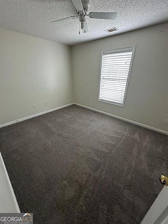 929 Wexford Way, Auburn, GA 30011 - spare room featuring a ceiling fan, a textured ceiling, dark colored carpet, and baseboards
