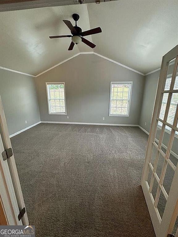 929 Wexford Way, Auburn, GA 30011 - spare room with baseboards, healthy amount of natural light, dark carpet, lofted ceiling, and ornamental molding