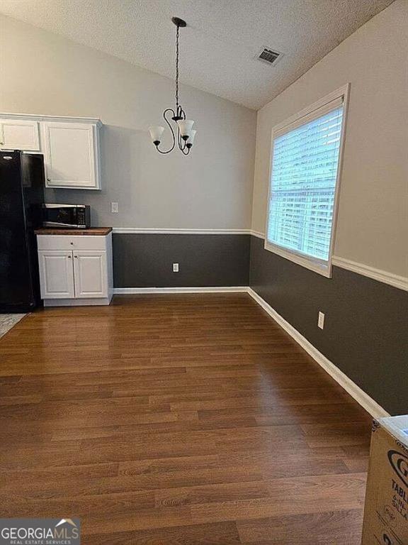 929 Wexford Way, Auburn, GA 30011 - kitchen featuring lofted ceiling, freestanding refrigerator, white cabinetry, a chandelier, and dark wood-style flooring