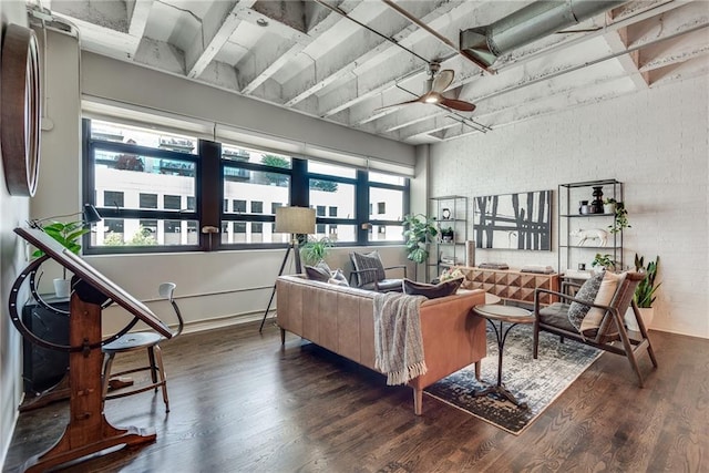 living room featuring dark hardwood / wood-style flooring, ceiling fan, and brick wall