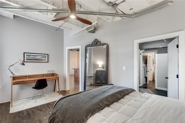 bedroom featuring a towering ceiling, ceiling fan, visible vents, and wood finished floors