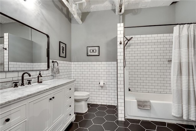 bathroom with tile patterned flooring, toilet, vanity, tile walls, and shower / bathtub combination with curtain