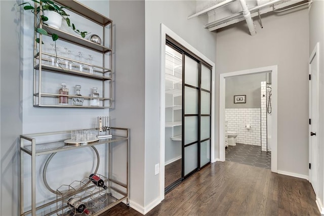 hallway featuring tile walls and wood finished floors