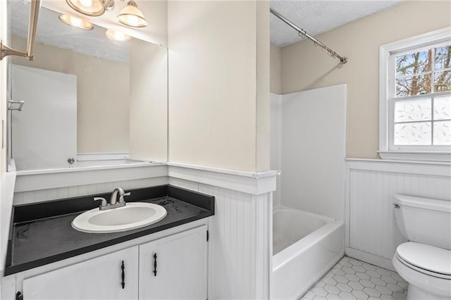 full bathroom with shower / washtub combination, vanity, a textured ceiling, tile patterned floors, and toilet