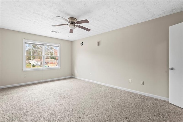 empty room with ceiling fan, a textured ceiling, and carpet