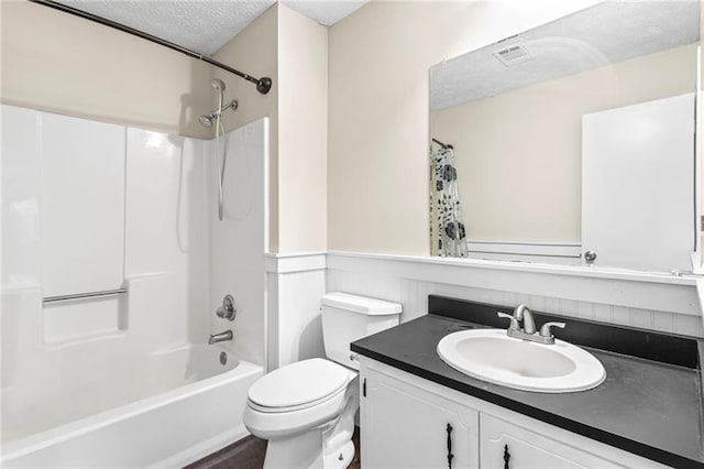 full bathroom featuring shower / tub combination, vanity, toilet, and a textured ceiling