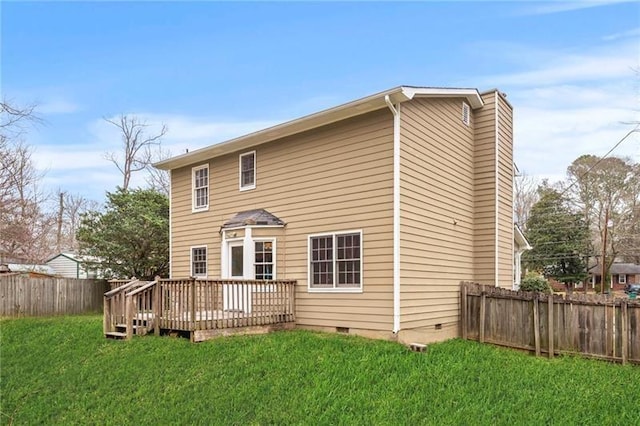 back of property featuring a wooden deck and a yard