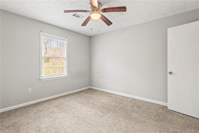 carpeted empty room featuring ceiling fan and a textured ceiling