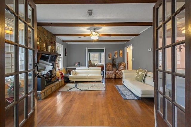 interior space featuring hardwood / wood-style floors, ceiling fan, beam ceiling, and french doors