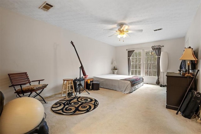 bedroom featuring ceiling fan, light colored carpet, and a textured ceiling