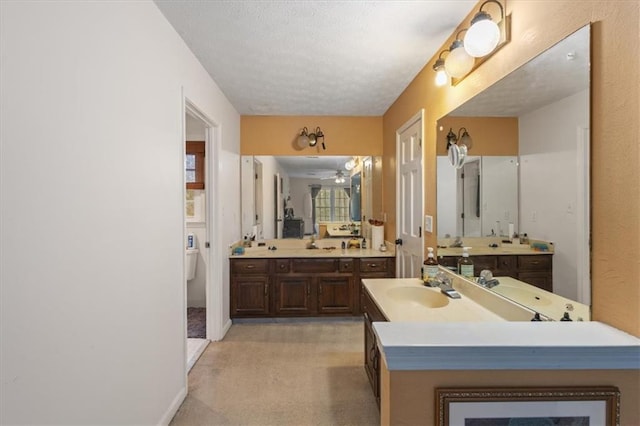 bathroom with vanity, toilet, and a textured ceiling