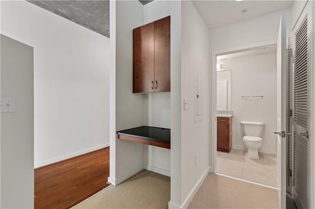 interior space with toilet, vanity, and hardwood / wood-style flooring