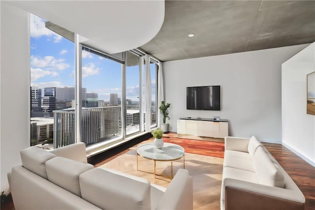 living room with hardwood / wood-style floors, expansive windows, and a healthy amount of sunlight