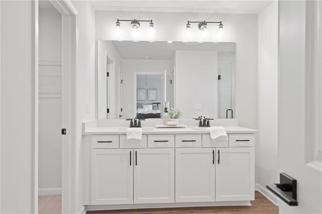 bathroom featuring vanity, wood-type flooring, and walk in shower