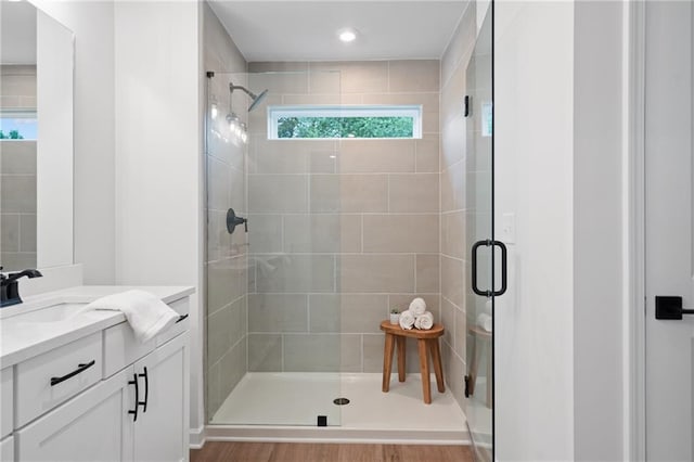 bathroom featuring hardwood / wood-style flooring, vanity, a shower with door, and a wealth of natural light