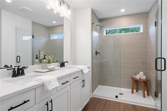 bathroom with vanity, a shower with shower door, and hardwood / wood-style flooring