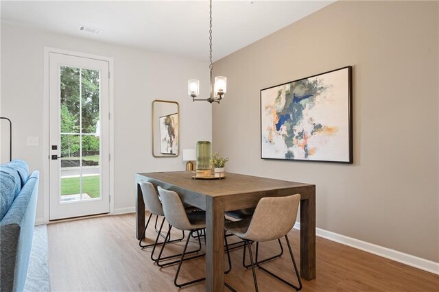 dining room with hardwood / wood-style flooring and a chandelier