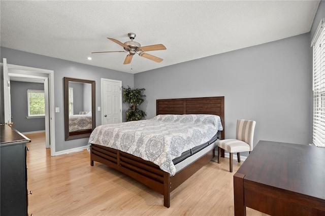 bedroom with a closet, light wood-type flooring, baseboards, ceiling fan, and recessed lighting
