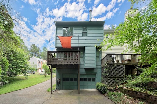 back of property with an attached garage, a deck, concrete driveway, a balcony, and a yard