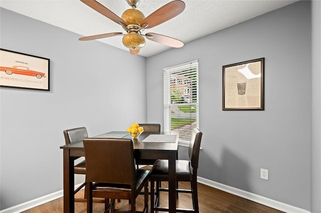 dining area with ceiling fan, baseboards, and dark wood finished floors