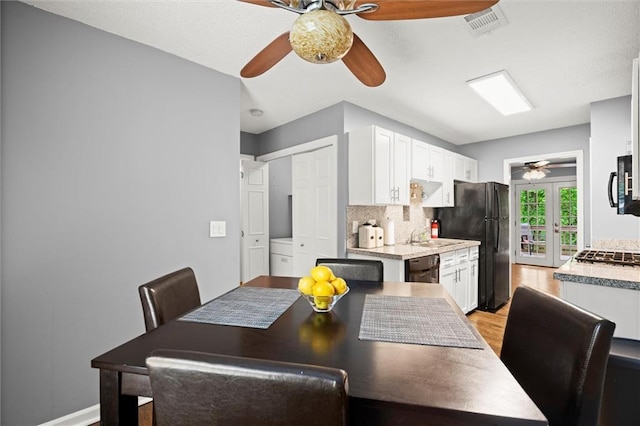 dining space featuring a ceiling fan, visible vents, and light wood-type flooring