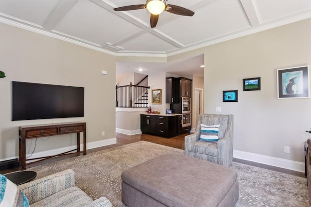 living area with coffered ceiling, ceiling fan, baseboards, stairs, and ornamental molding