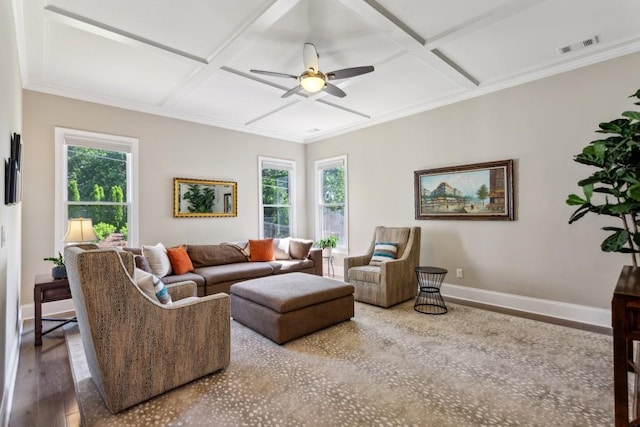 living room with coffered ceiling, ceiling fan, healthy amount of natural light, baseboards, and wood finished floors