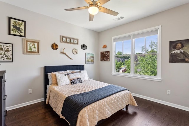 bedroom featuring baseboards, wood finished floors, and a ceiling fan