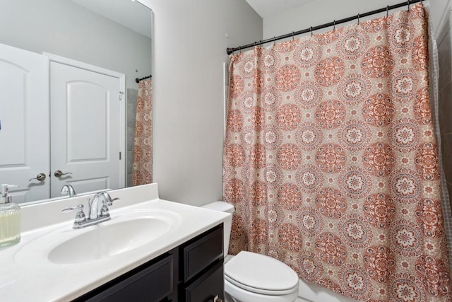 bathroom with toilet, vanity, and curtained shower