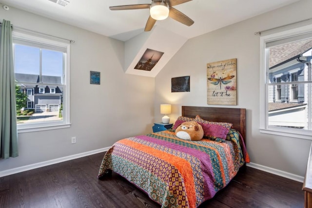 bedroom featuring multiple windows, wood finished floors, baseboards, and vaulted ceiling