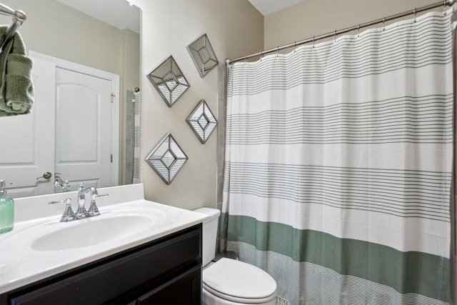 bathroom featuring toilet, vanity, and a shower with shower curtain