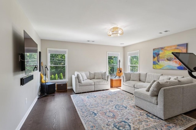 living area with plenty of natural light, dark wood-style floors, and baseboards