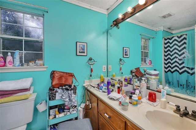 bathroom with toilet, vanity, a shower with curtain, crown molding, and a textured ceiling