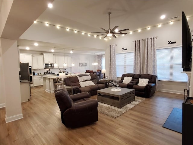 living room with ceiling fan and light wood-type flooring