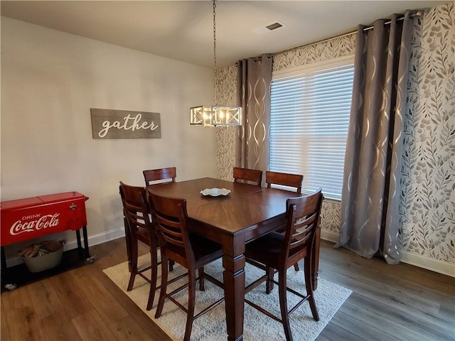 dining area featuring dark hardwood / wood-style flooring and an inviting chandelier