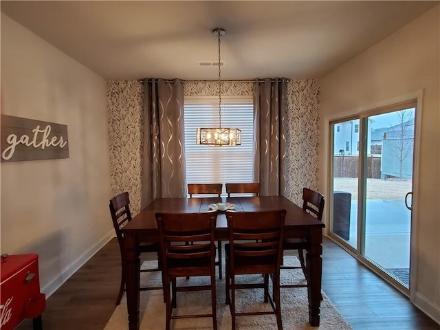 dining room with dark wood-type flooring and a chandelier