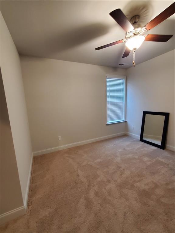 carpeted empty room featuring ceiling fan