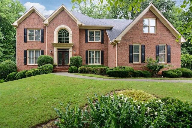 5404 Chaversham Ln, Peachtree Corners, GA 30092 - colonial house featuring french doors, a front yard, and brick siding