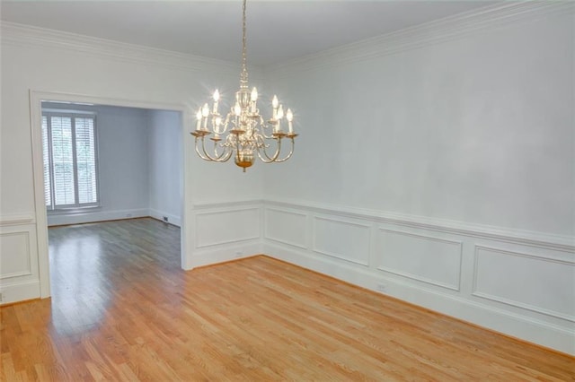 5404 Chaversham Ln, Peachtree Corners, GA 30092 - empty room with a chandelier, light wood finished floors, ornamental molding, a decorative wall, and wainscoting