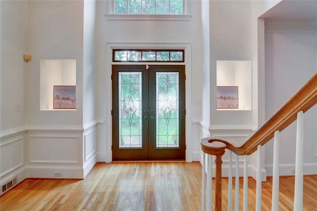 5404 Chaversham Ln, Peachtree Corners, GA 30092 - entrance foyer featuring french doors, wood finished floors, plenty of natural light, wainscoting, and a decorative wall