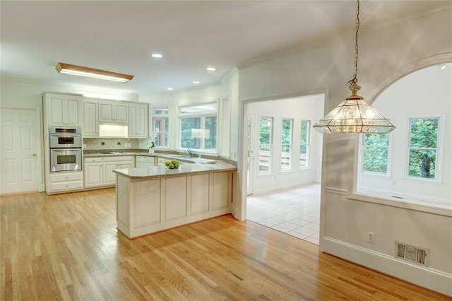 5404 Chaversham Ln, Peachtree Corners, GA 30092 - kitchen with white appliances, a peninsula, light wood-type flooring, a sink, and ornamental molding