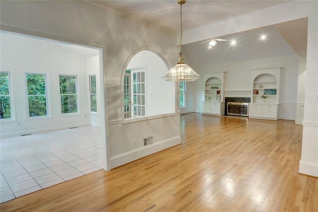 5404 Chaversham Ln, Peachtree Corners, GA 30092 - unfurnished living room featuring built in shelves, ornamental molding, a chandelier, light wood-style flooring, and baseboards