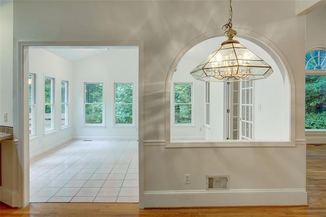 5404 Chaversham Ln, Peachtree Corners, GA 30092 - unfurnished dining area with a chandelier, plenty of natural light, baseboards, and wood finished floors