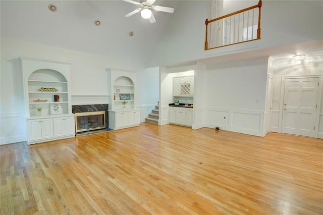 5404 Chaversham Ln, Peachtree Corners, GA 30092 - unfurnished living room with a high end fireplace, high vaulted ceiling, stairway, built in features, and a ceiling fan