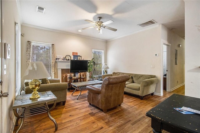 living room with hardwood / wood-style flooring, ornamental molding, and ceiling fan