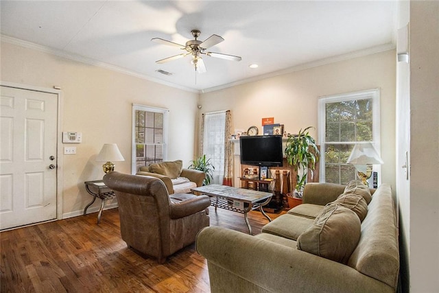 living room with ornamental molding, dark wood-type flooring, and ceiling fan